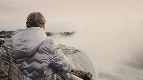 the child looks at the famous niagara falls, the view from behind. usa tourism