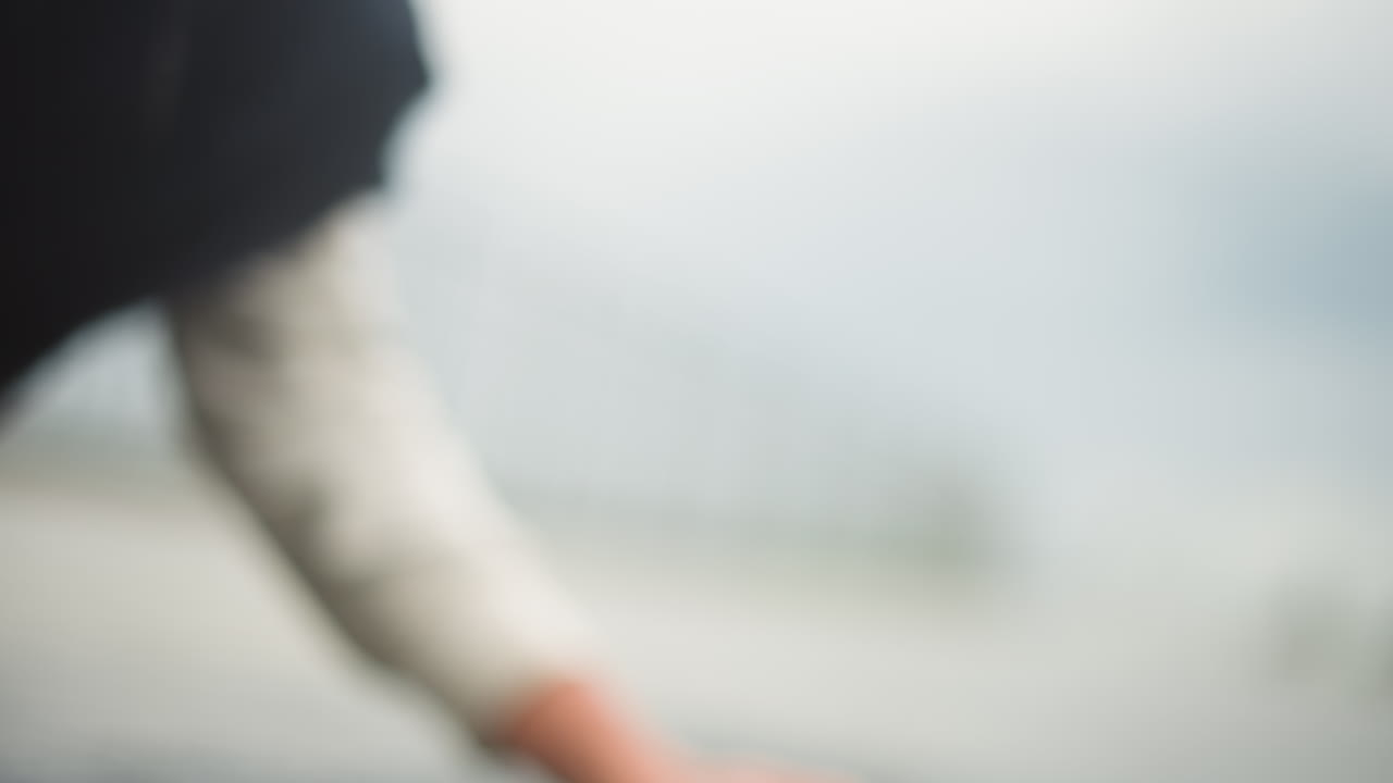 백인 손이 천천히 물웅덩이의 물을 모으고, 신중하게 물방울을 움켜쥡니다. 흐릿한 다리 수평선, 젖은 콘크리트의 반사, 부드러운 소매와 부츠, 조용한 환경의 반영, 치유되는 분위기