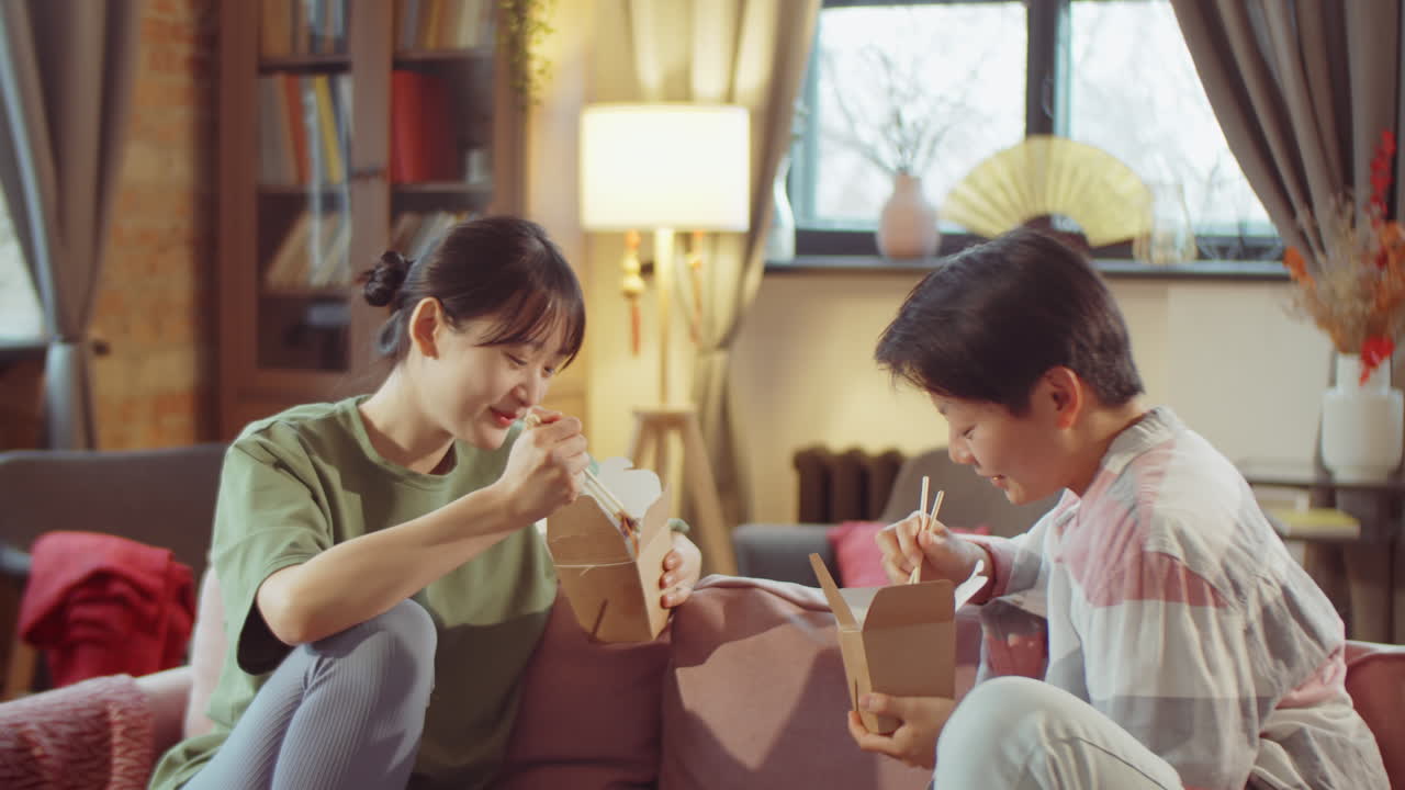 Asian Women Eating Wok from Takeaway Boxes at Home