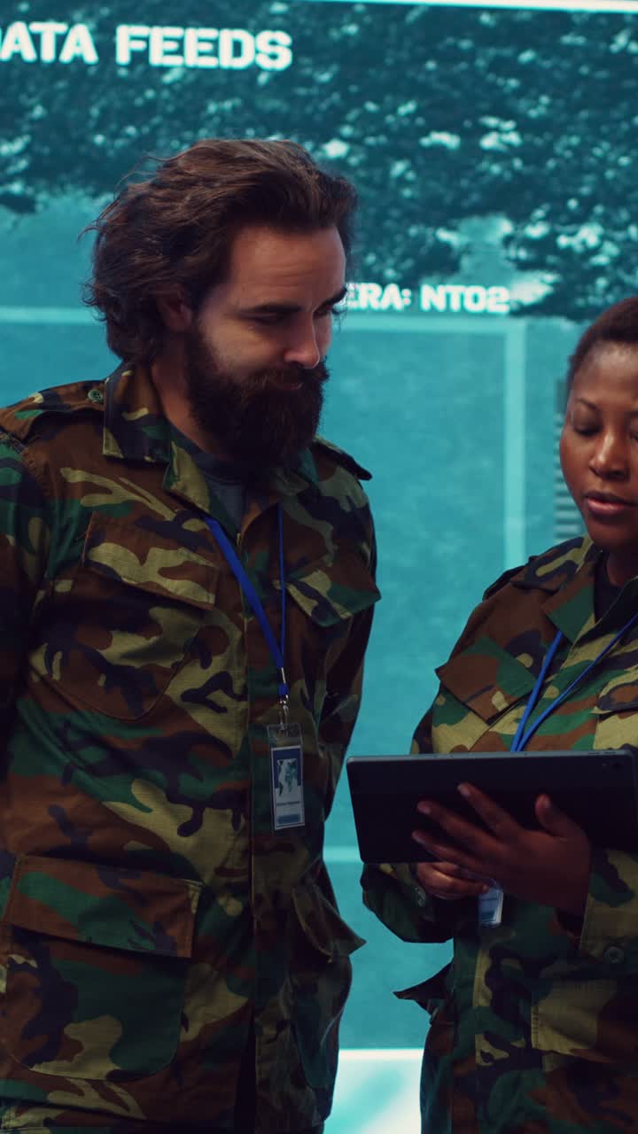 Military Personnel Discussing Data on Tablet in Command Center