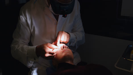 optometrist examining patient eyes with eye test equipment in clinic 4k