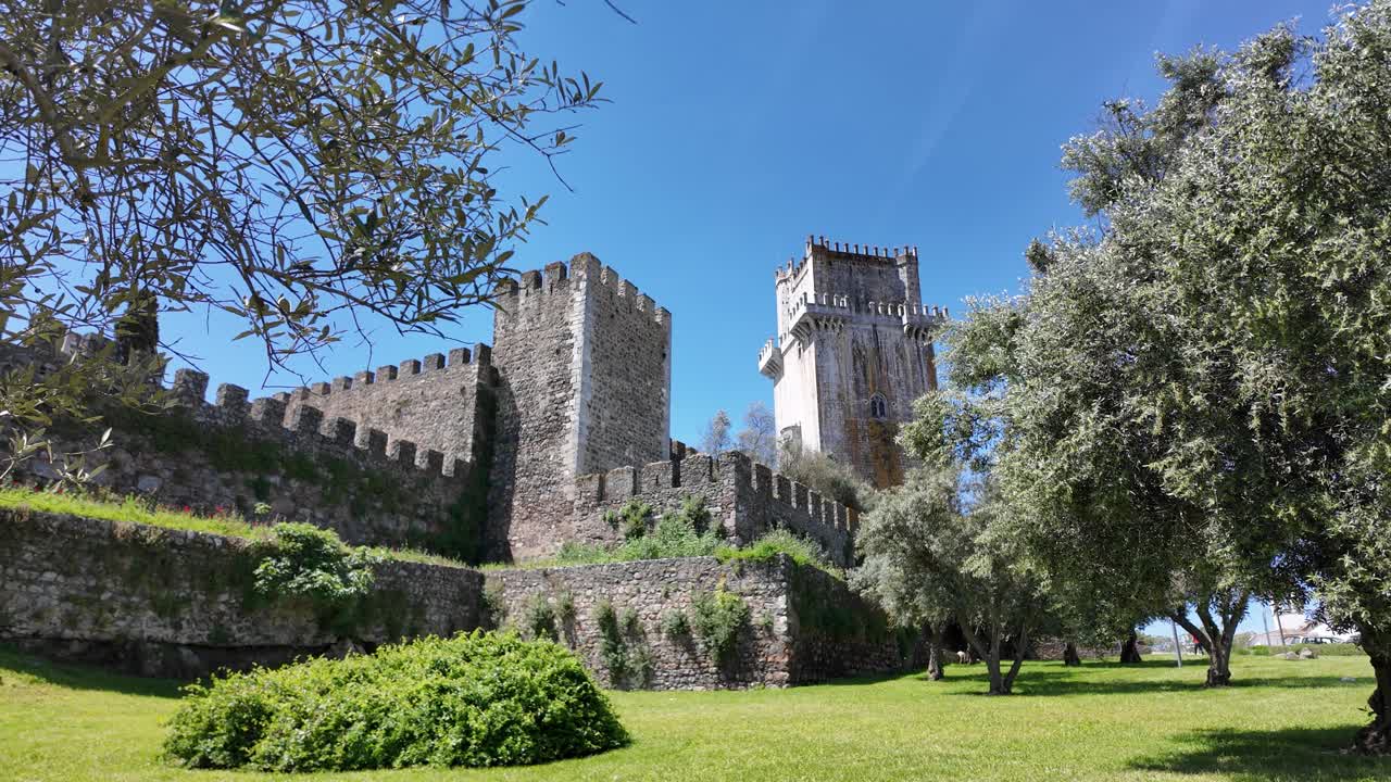 Medieval stone fortress and towering keep rise above gardens in Beja Portugal