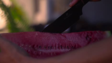 cortando una sandía jugosa con un cuchillo de chef negro