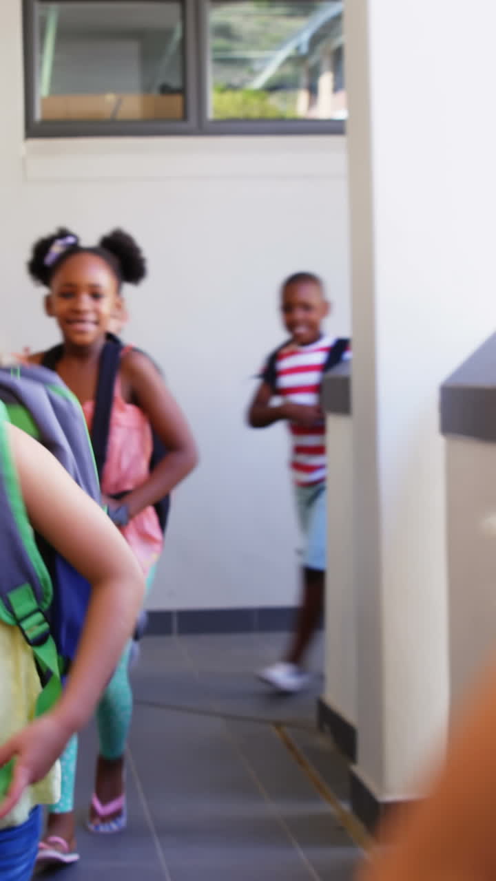 Smiling school kids running in corridor