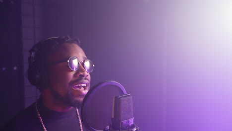 man singing into microphone in recording studio