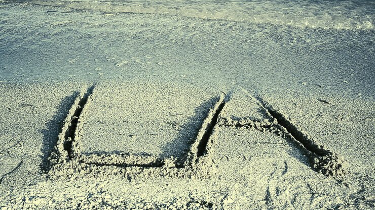 The inscription LA on sand. Inscription on sand, the beach