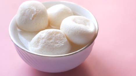 close up of indian sweet in a white bowl on pink background