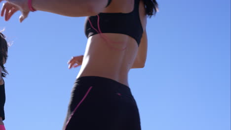 Two-athletic-friends-stretching-on-promenade-before-run