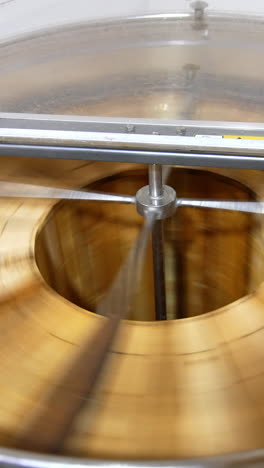 automatic honey extracting machine rotating many frames at once. barrel-like apparatus removing honey from honeycombs. top view. vertical video