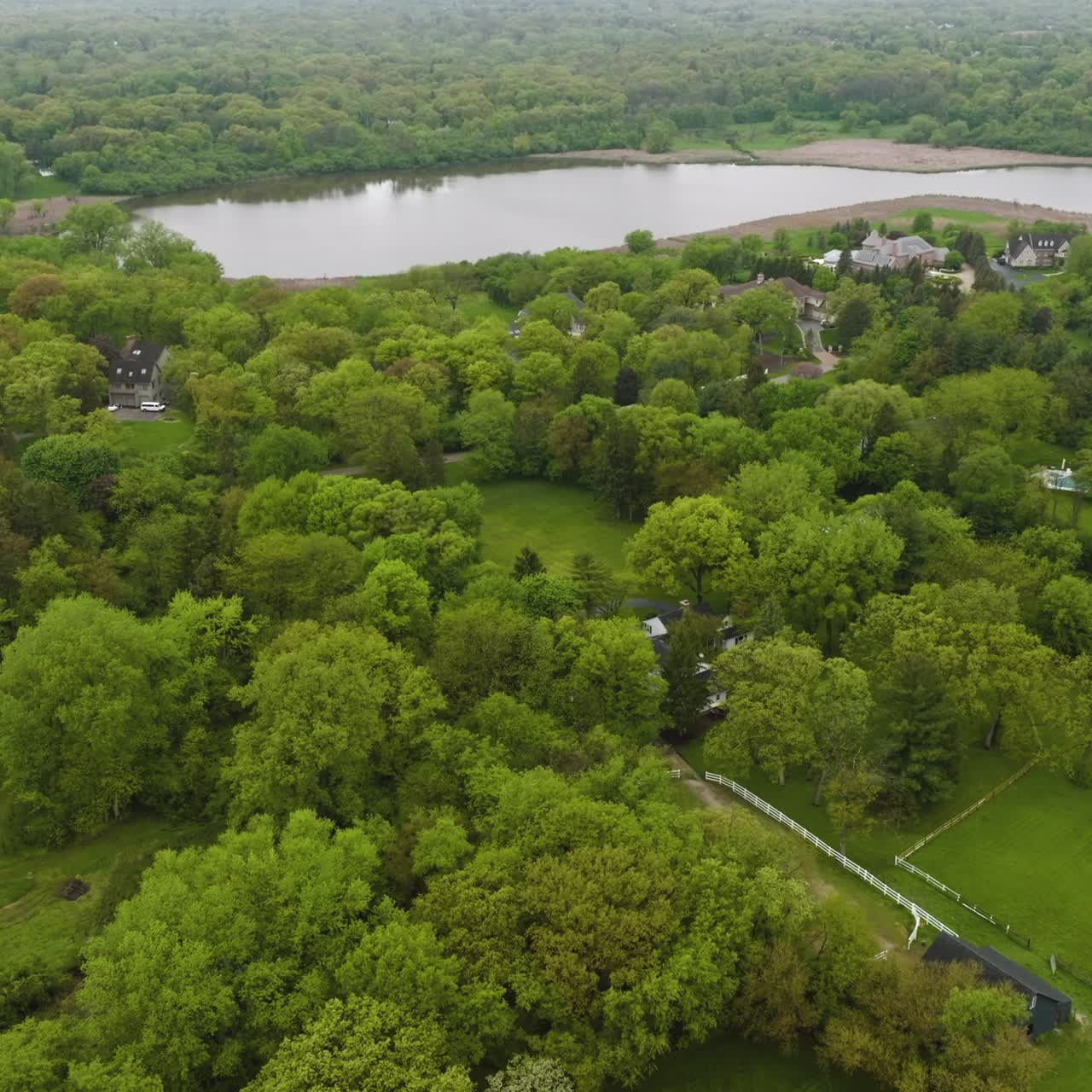 Nice private houses half-hidden in the green trees. Beautiful rural American suburb located at the river bank. top view