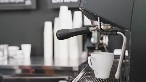 caucasian male barista preparing coffee with coffee machine in cafe