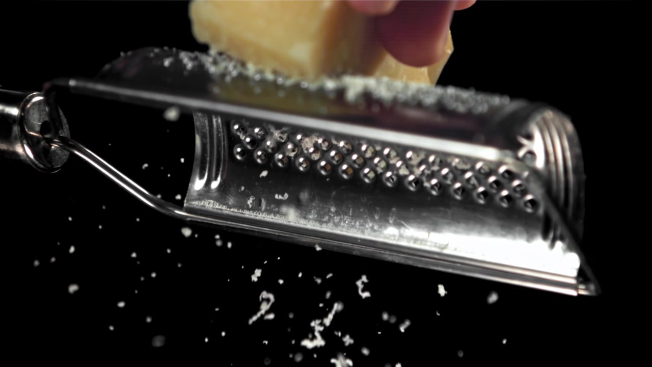 Primo piano al rallentatore di grattugiatura di Parmigiano.