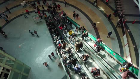 busy crowd on escalator in a large shopping mall