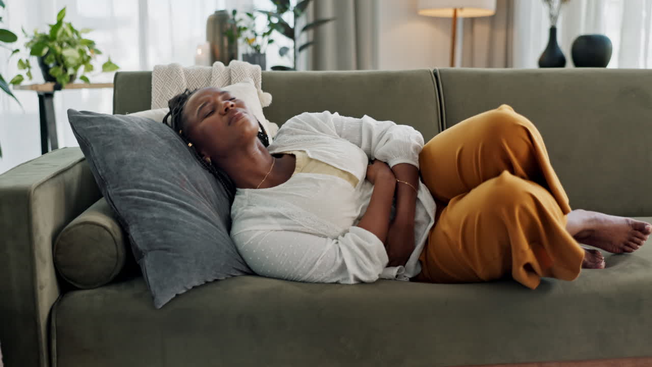 Home, pain and black woman on a couch
