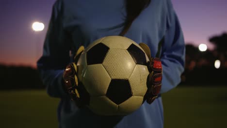 female soccer player holding the ball on soccer field. 4k