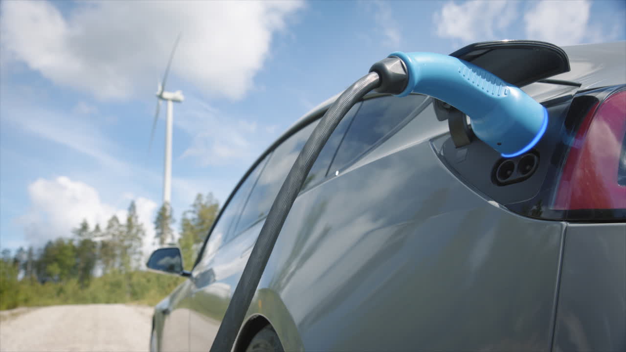 ANIMATED GRAPHICS ENHANCED - A generic electric car charges in front of a wind turbine