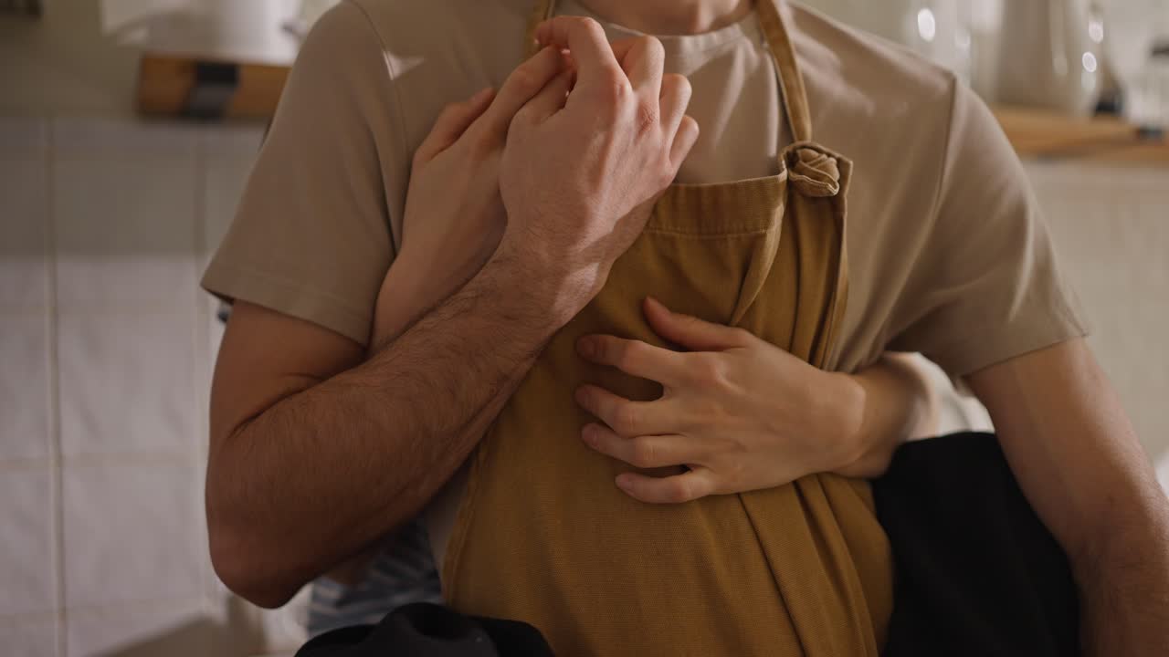 una pareja abrazándose en la cocina.