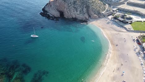 Santa-Maria-Beach-with-a-sailboat-in-the-bay-and-people-on-the-beach