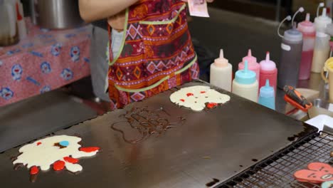 Mujer-Preparando-Panqueques-En-Forma-De-Dibujos-Animados-En-Parrilla-Plana,-Bangkok