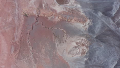 Birds-eye-perspective-flying-over-colorful-rock-formation-near-Tuba-City,-AZ