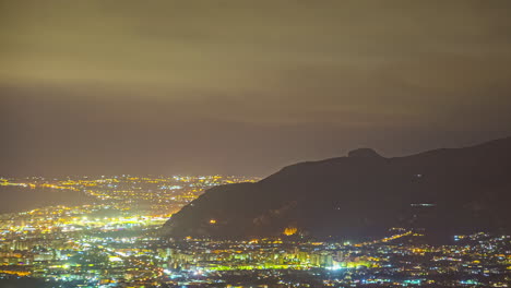 luces nebulosas de la ciudad nocturna, vistas desde una colina en sicilia, italia