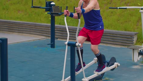 Senior-man-grandfather-80-years-old-doing-sport-training-exercising-workout-on-orbitrek,-playground