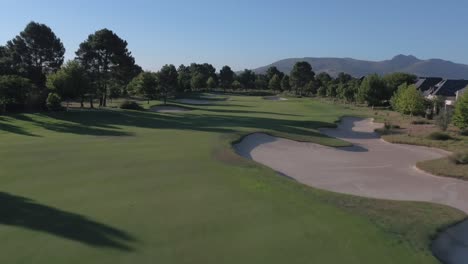 low level drone aerial tracking shot over magnificent golf course fairway at pearl valley golf estate in western cape, south africa