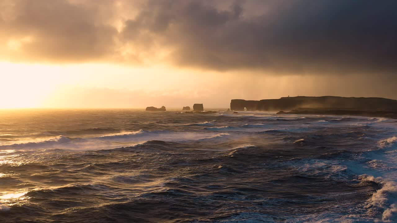 Enthralling Aerial Perspectives of Iceland's Black Sand Beach, Highlighting the Strength of Waves During Sunset