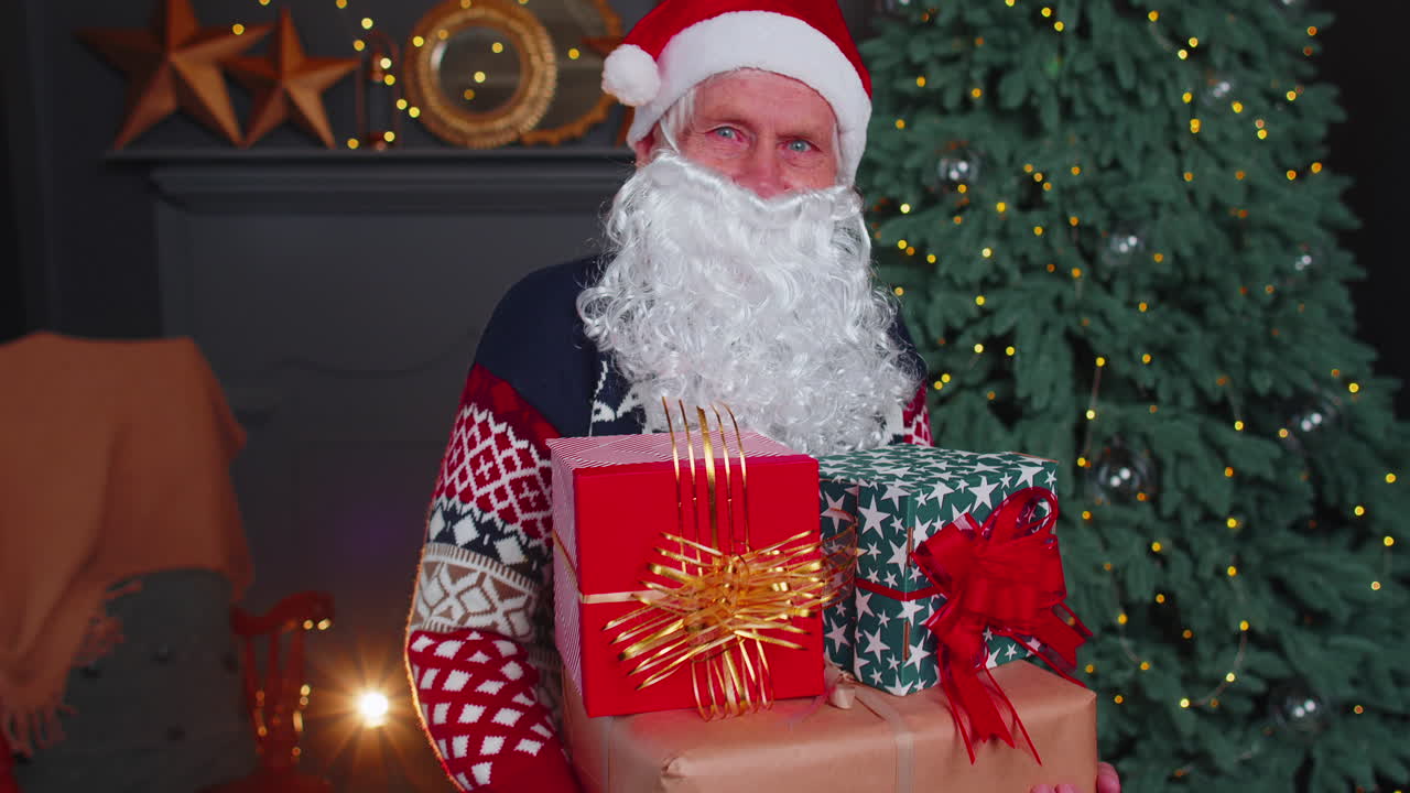 el abuelo mayor parodia a papá noel presentando una caja de regalo de navidad, celebración navideña en casa