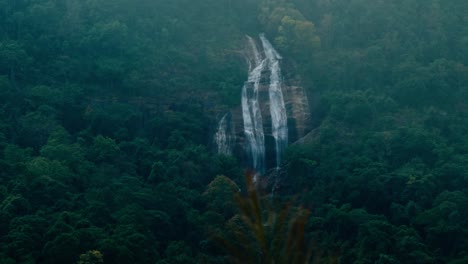 tall waterfall cascading through lush green forest