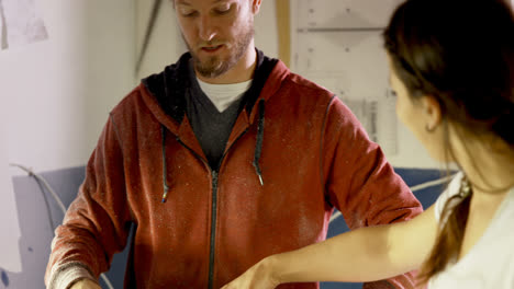 man and woman interacting with each other while making surfboard 4k