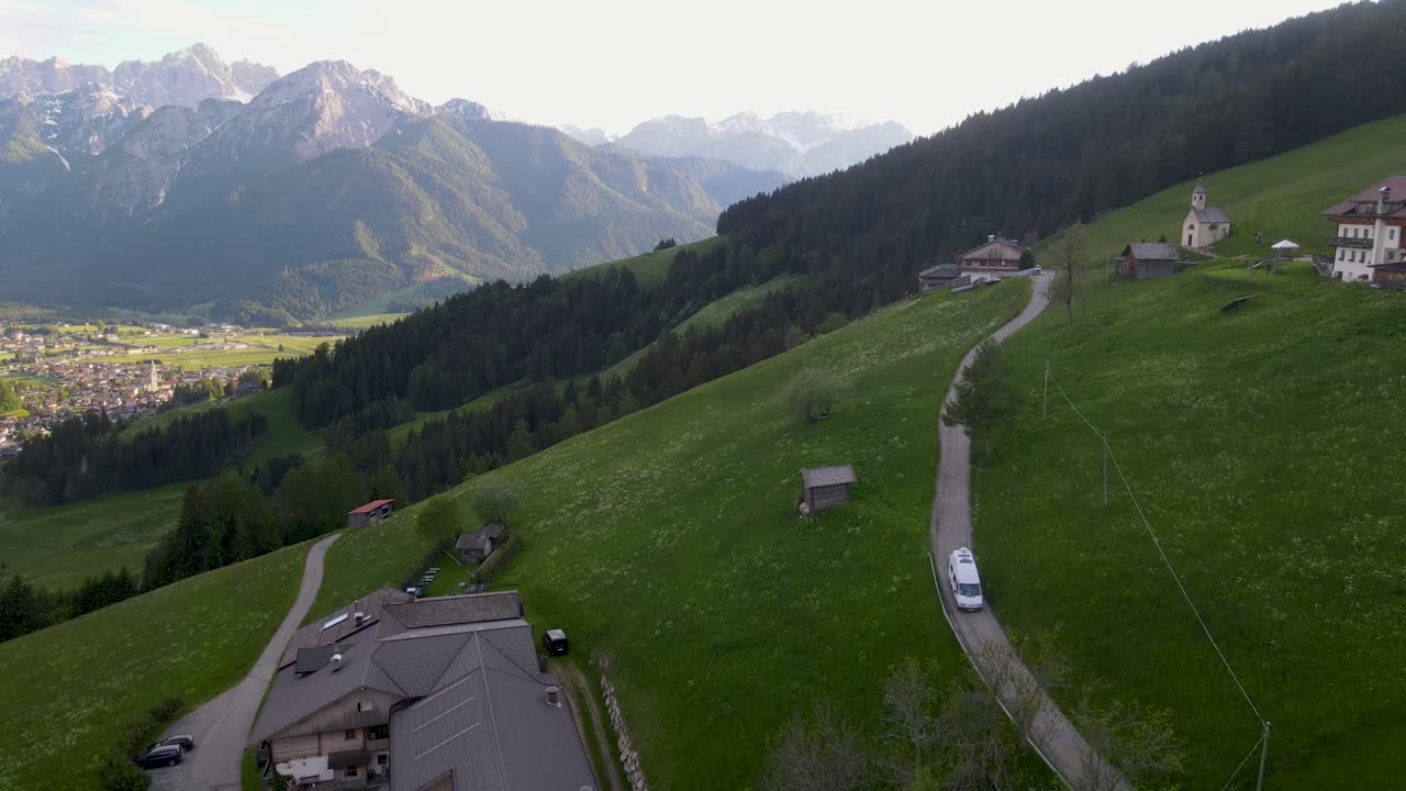 una furgoneta conduce por un camino de campo fuera de toblach, italia en esta toma de avión no tripulado