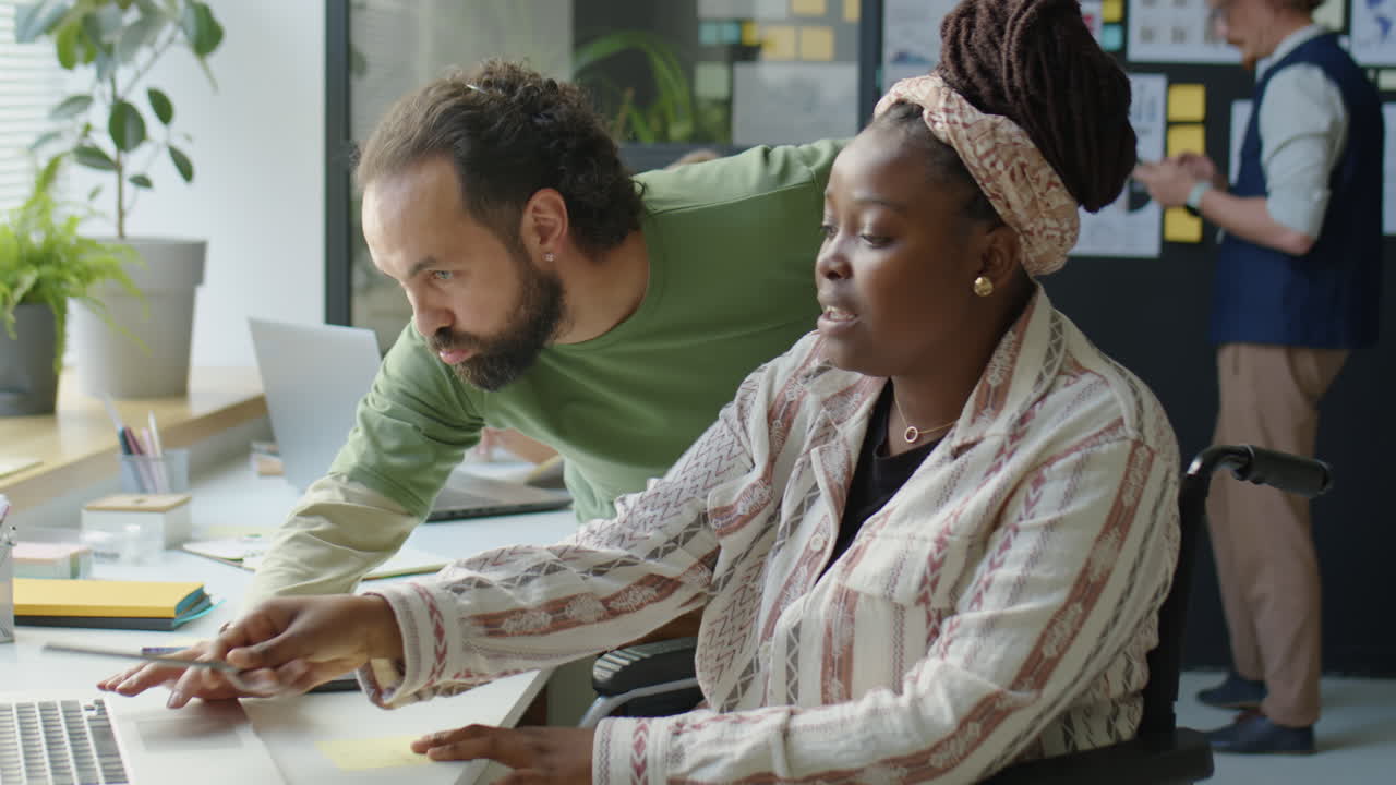 Man Discussing Project with Female Colleague in Wheelchair