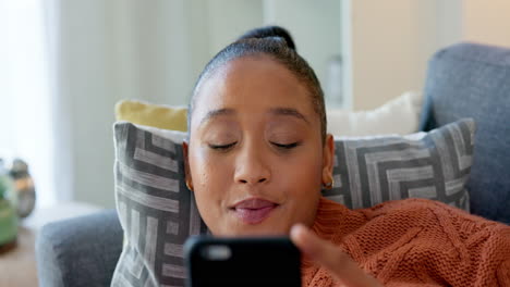 mujer joven feliz usando un teléfono mientras miente
