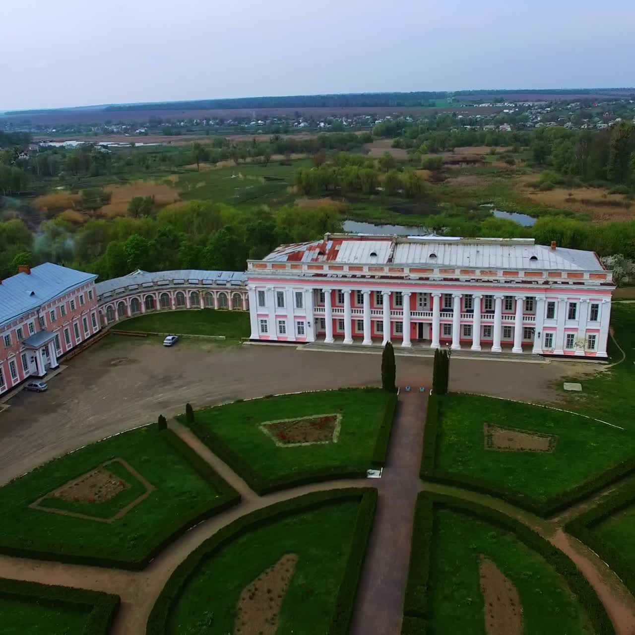 Three historical buildings in the ensemble of museum. Palaces under reconstruction with flower-bed in the middle. Cityscape at backdrop