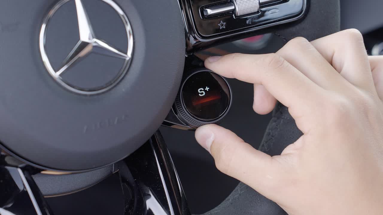 Close-Up of Hand Adjusting Driving Mode Dial Inside Mercedes Sports Car