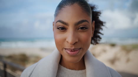 portrait happy african american look camera at autumn beach. joyful tourist rest