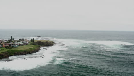 aerial drone shot flying towards and around gerroa headland on a stormy day in south coast nsw australia