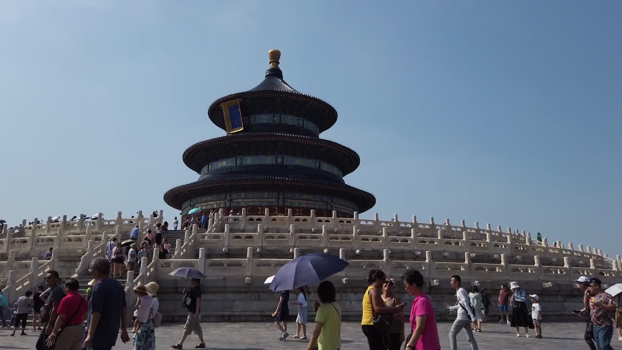 Mid range static shot of Temple of Heavens in Beijing, China. People walking around and taking selfies.