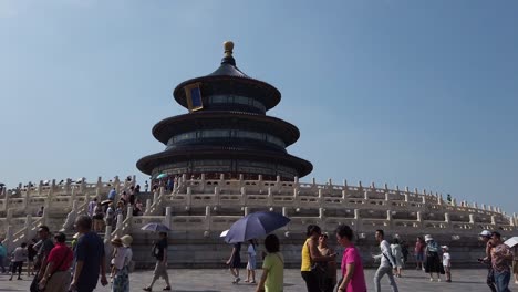 mid range static shot of temple of heavens in beijing, china. people walking around and taking selfies.