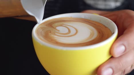 Ein-Geschickter-Barista,-Der-Eine-Latte-Art-Mit-Rosetta-Muster-In-Eine-Gelbe-Kaffeetasse-Gießt-|-Gourmet-Kaffeehaus-|-Aufnahme-In-HD-Mit-Filmischen-24-Fps