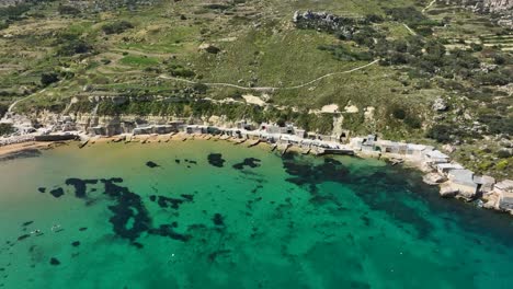 Disfrute-Del-Encanto-Intacto-Del-Ambiente-Sereno-De-La-Bahía-De-Gnejna,-Mientras-Las-Amplias-Vistas-Del-Mediterráneo-Se-Despliegan-Desde-Los-Cielos.