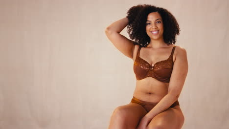 studio portrait shot of smiling confident natural woman in underwear promoting body positivity