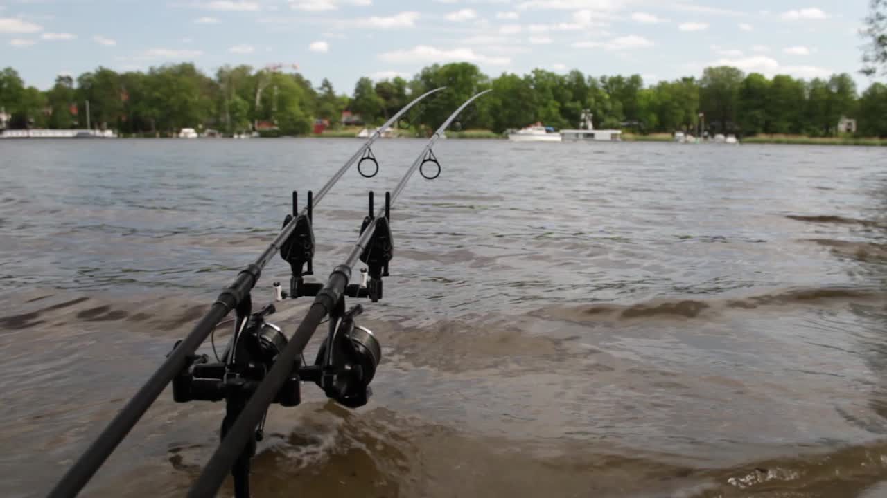 Fishing rod´s on the lakeside with a boat in the backround