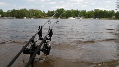 fishing rod´s on the lakeside with a boat in the backround