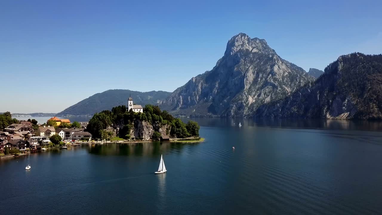 vuelo sobre la iglesia de traunkirchen en el lago traunsee, en salzkammergut, alta austria.