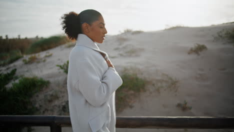 sad woman walking pier in morning sunlight. worried beautiful african american