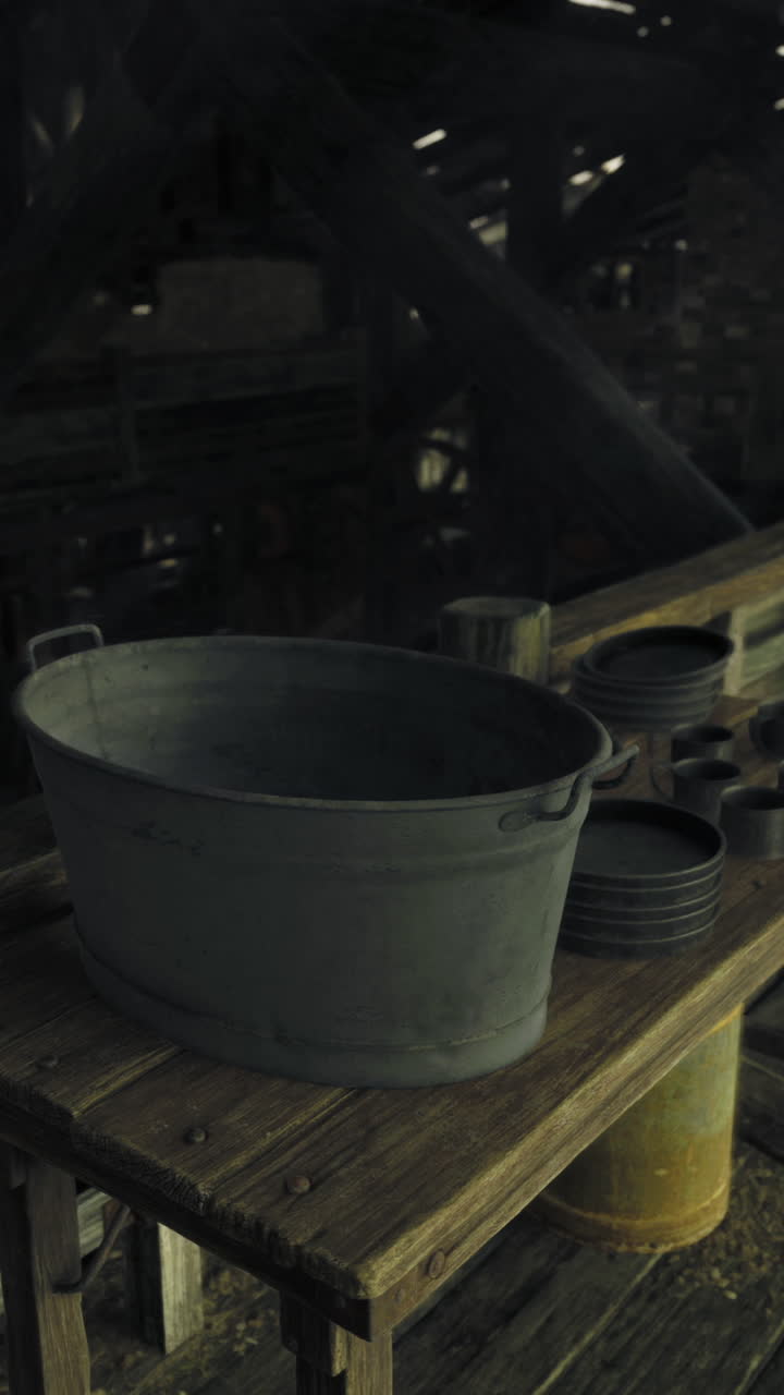 Old wooden barn interior featuring a metal container and rustic utensils