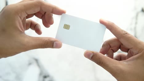 hands holding a blank white credit card