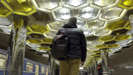 person walking in a beautiful metro station with honeycomb ceiling